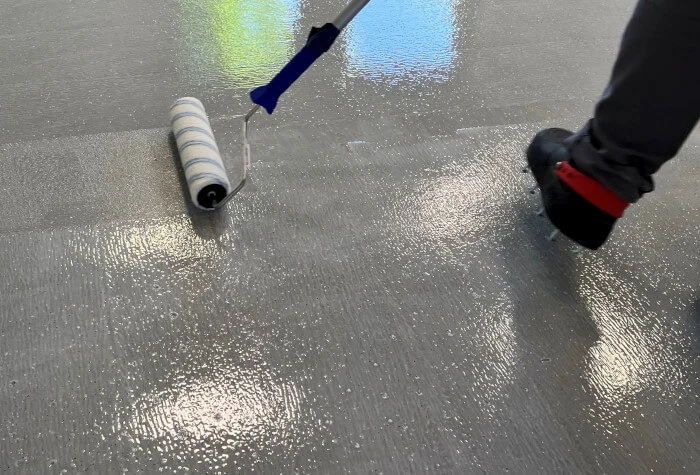 Graue PU-Bodenbeschichtung wird mit einer Walze aufgetragen